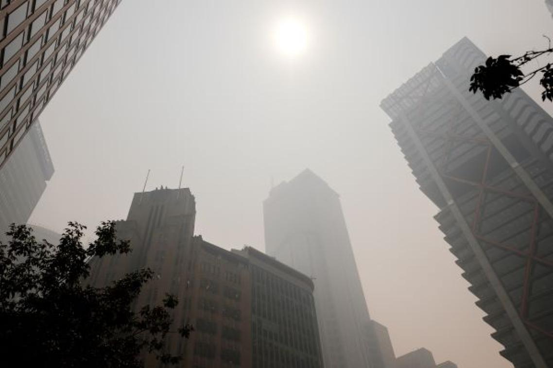 Sun shining through smoke onto high-rise buildings. Adobe