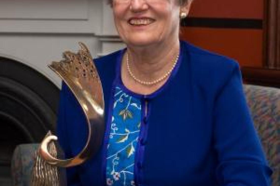 A woman in a blue dress holding a trophy