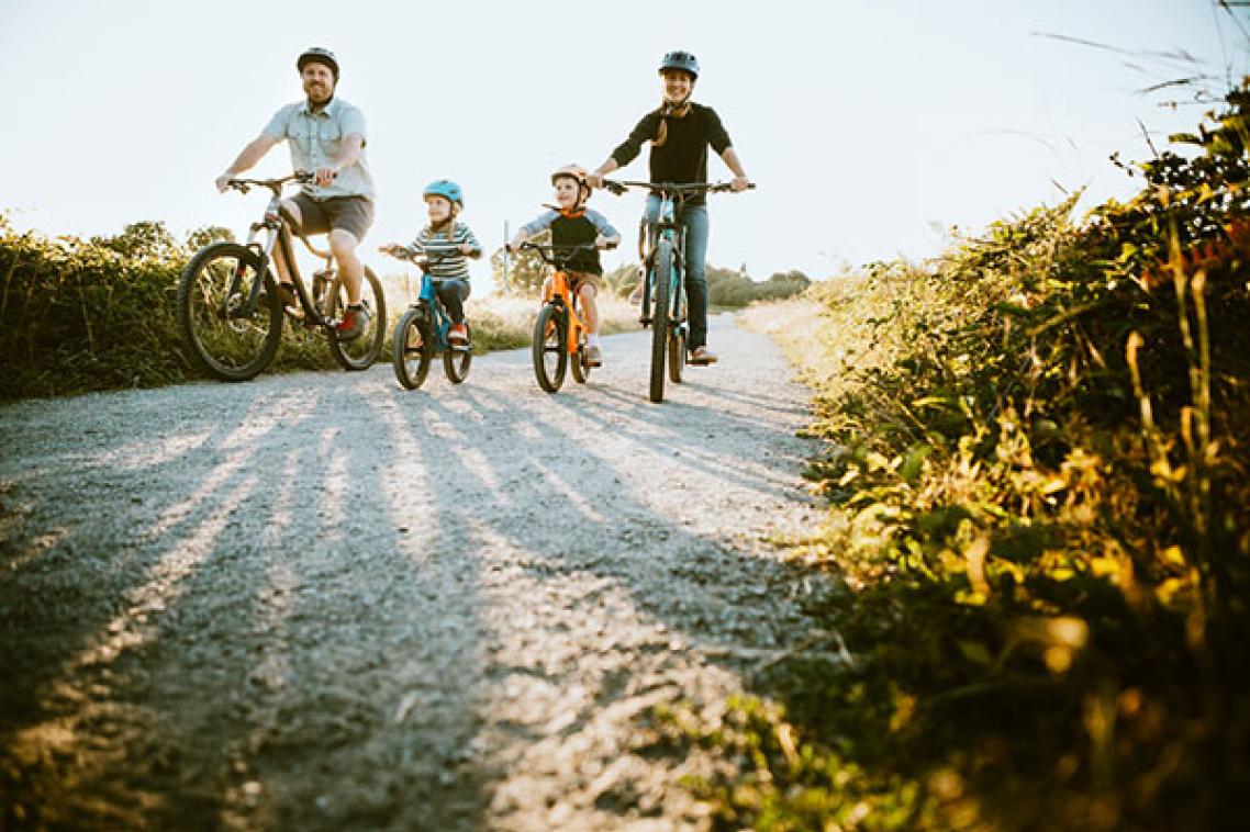 Man and woman on bikes flanking two small children on bikes