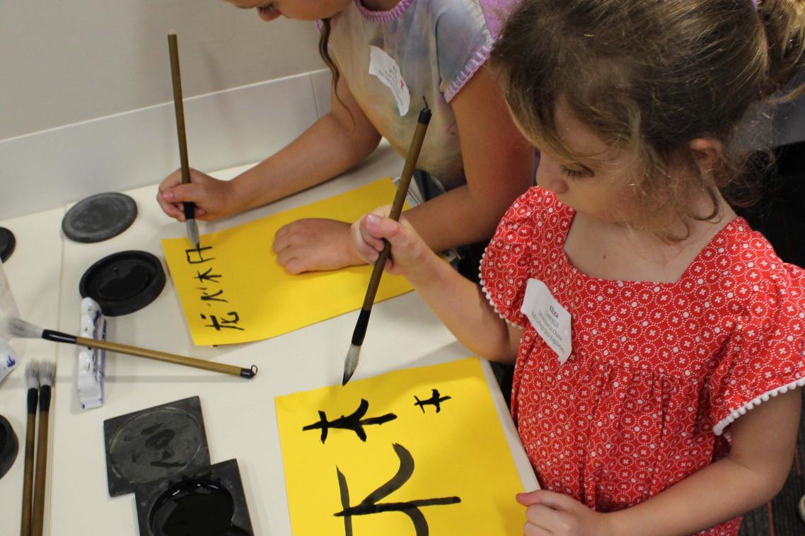 Children doing calligraphy at Explorama