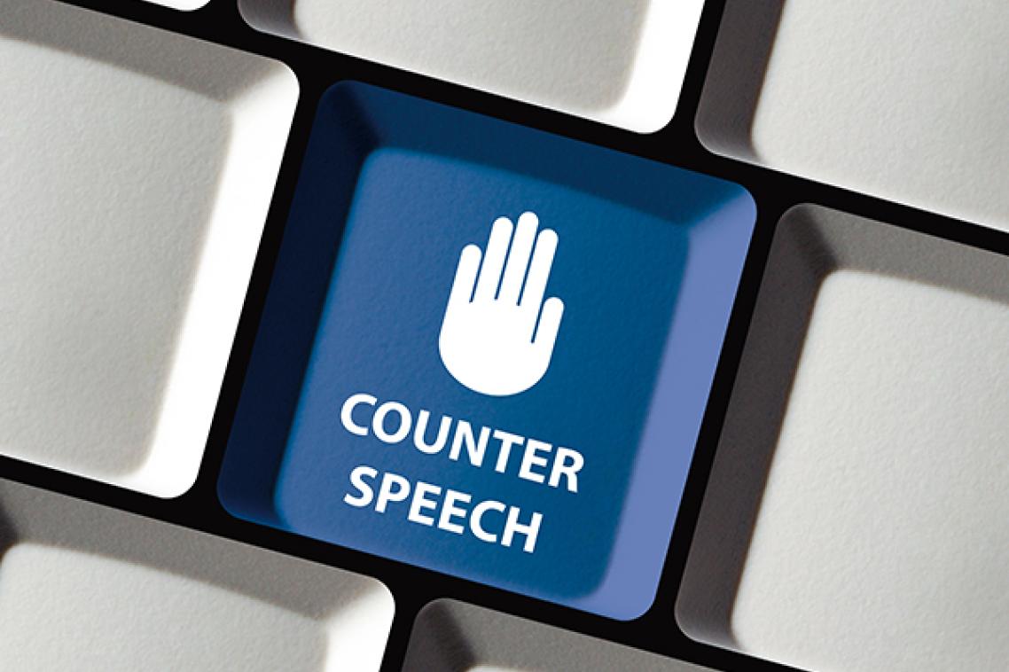 Picture of the palm of a hand in the stop pose on a Facebook-blue coloured key on a computer keyboard