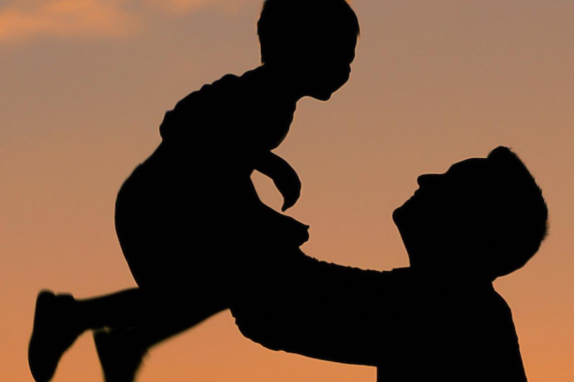Silhouette of father and son playing