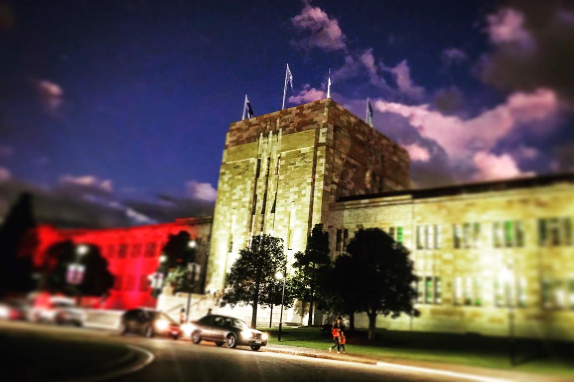 UQ's Forgan Smith building lit in Aboriginal flag colours.