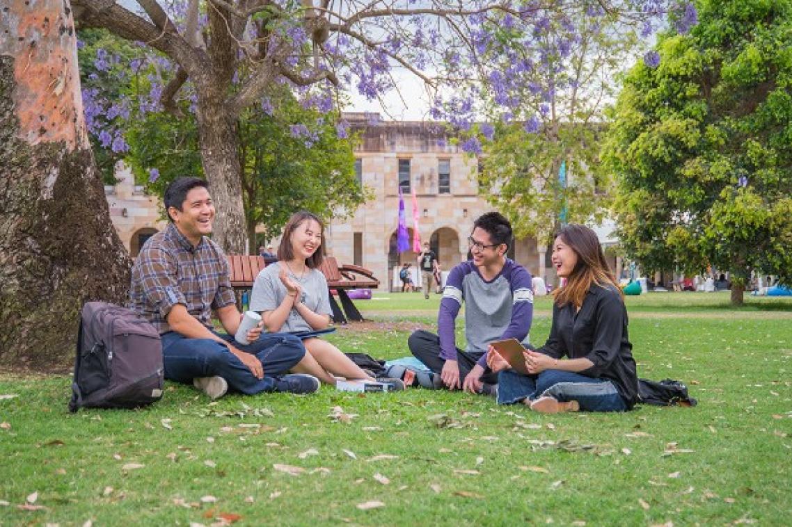 Group of students sit in UQ Great Court.