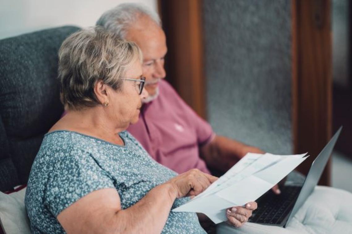 An elderly man and woman looking over a sheet of paper
