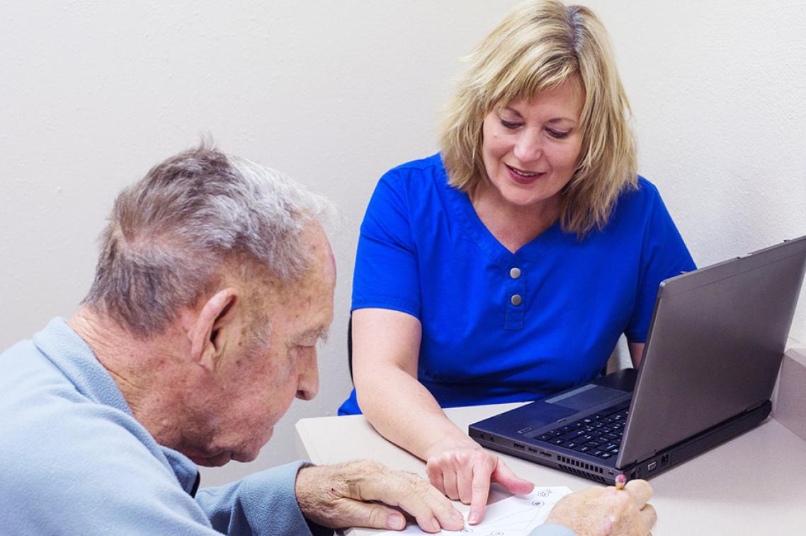 Stock image: A female doctor sitting with an elderly male patient