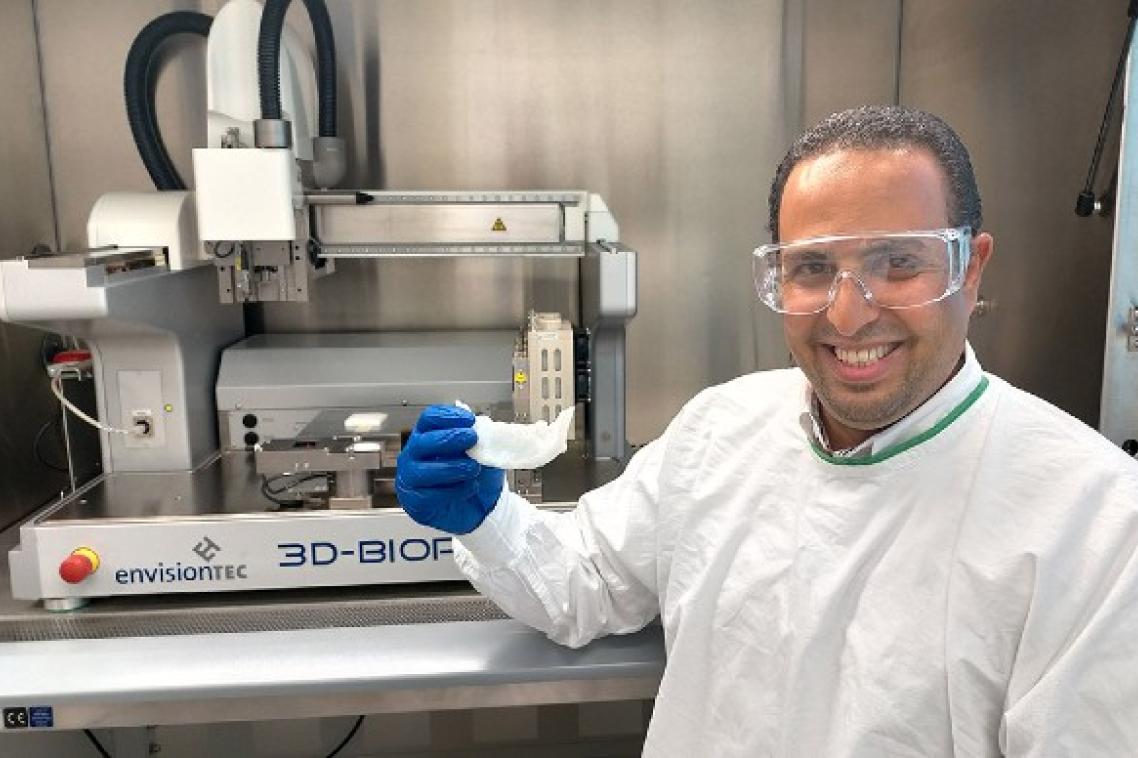 UQ researcher Dr Abdalla Ali holding a 3D-printed bone scaffold in a laboratory.
