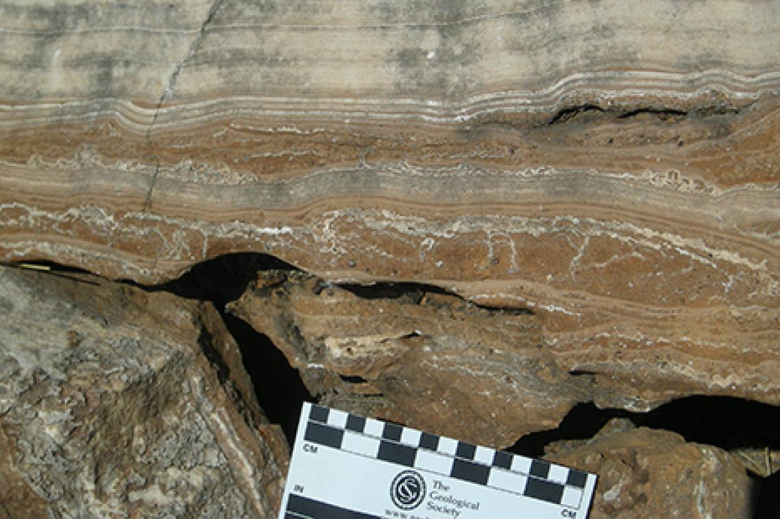field photograph of massive flowstone layers from one of the South African hominin caves, with red cave sediments underneath. Photo credit: Dr Robyn Pickering