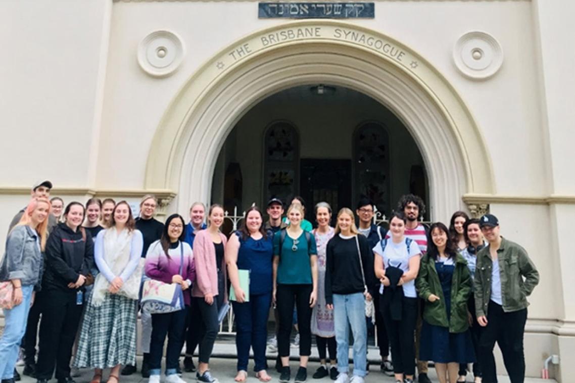a group of people stand in the arched entrance to a synagogue