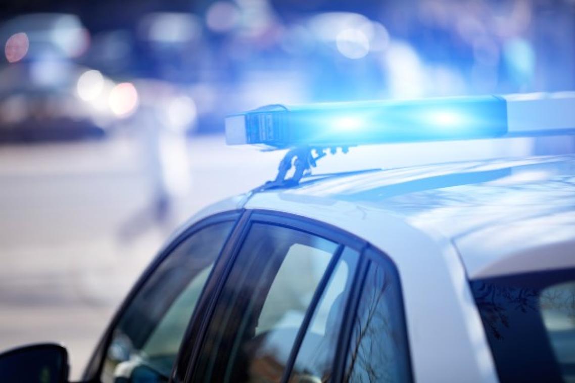 Police car with blue lights in urban setting.