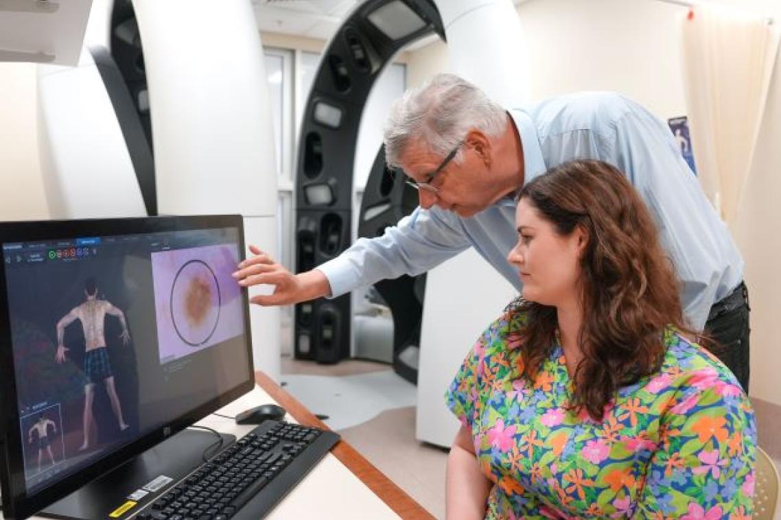 Researchers studying skin lesions on computer image. Credit, UQ