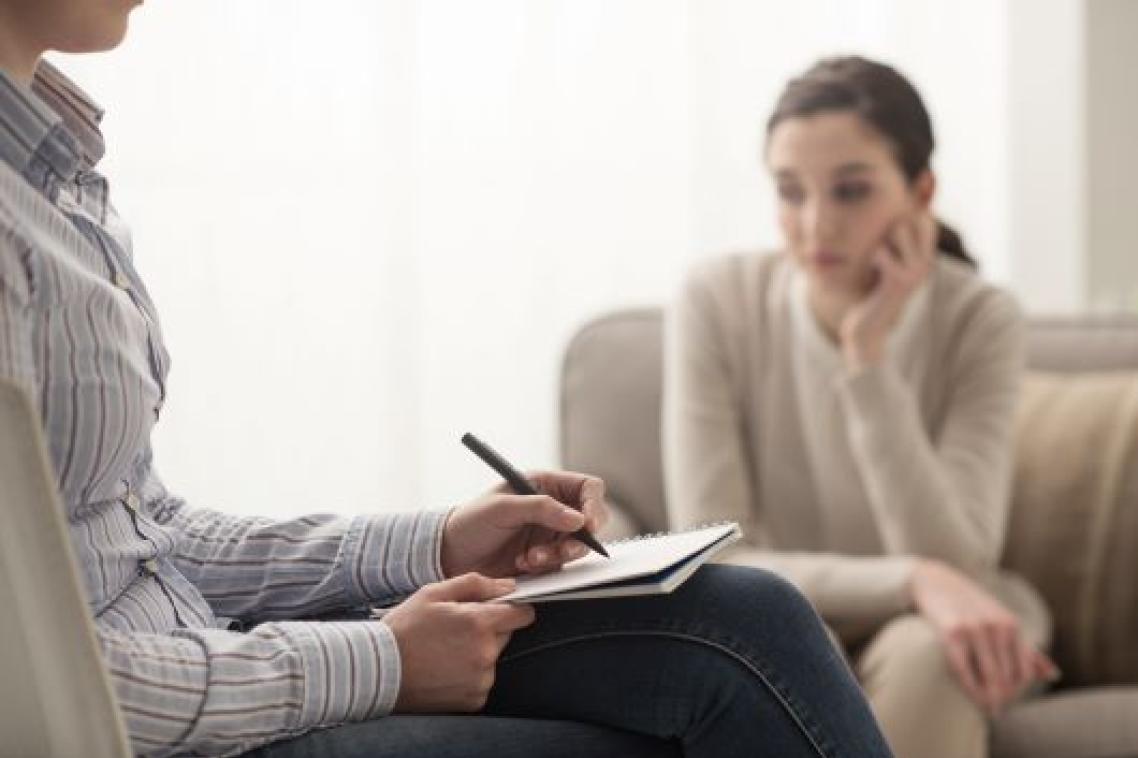 Woman sitting near another person writing notes.
