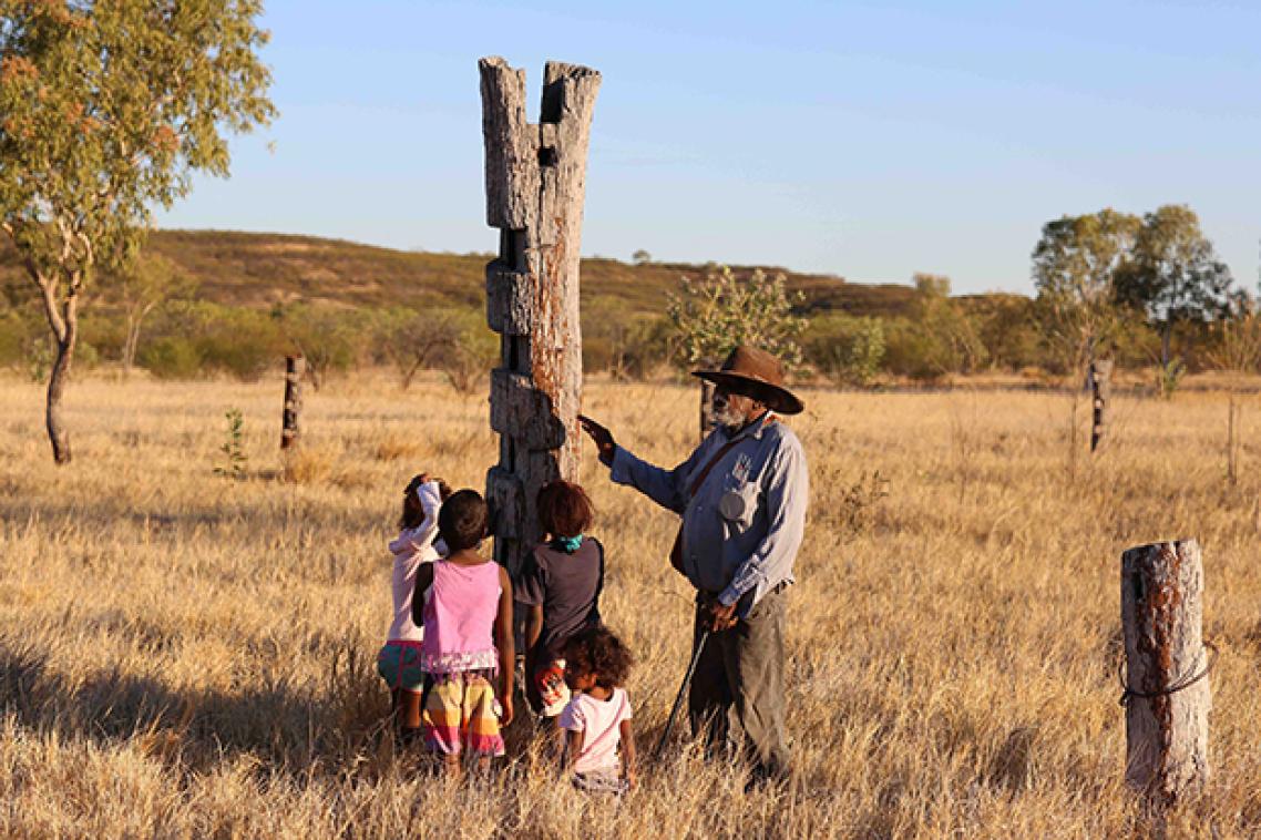An indigenous man speaking to his grandchildren