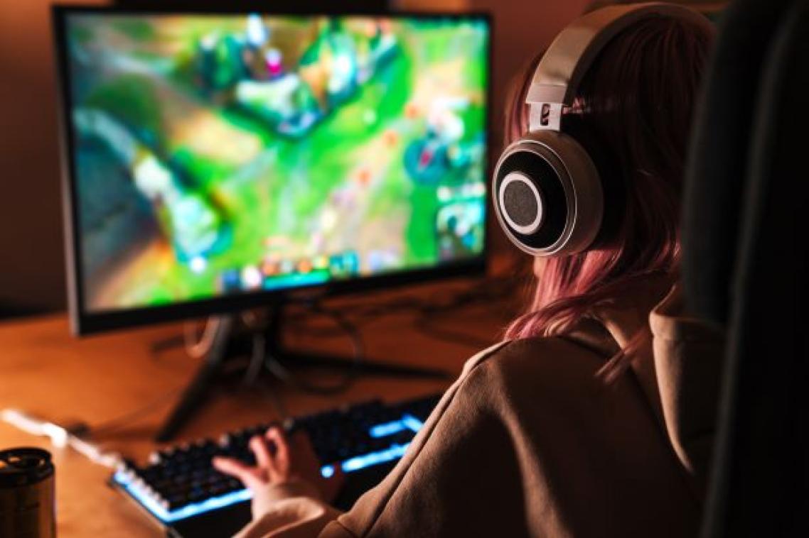 Young woman playing games on a personal computer. Image, Adobe.