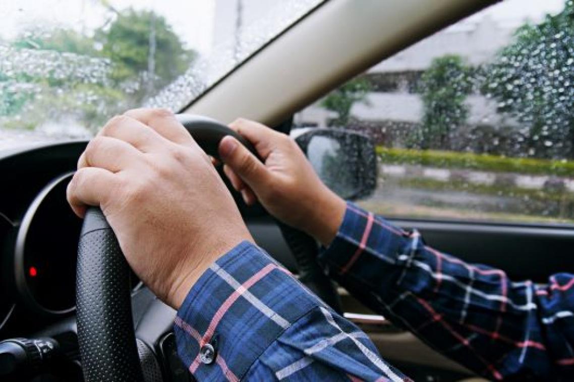 A pair of hands on a car steering wheel.