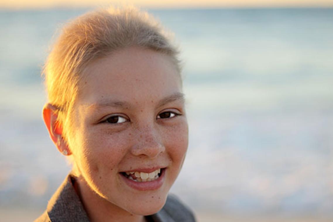 Headshot of a girl on a beach.