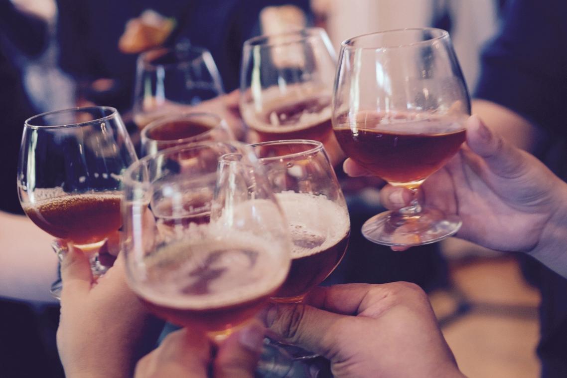 Stock image: people holding glasses of alcohol to 'cheers'