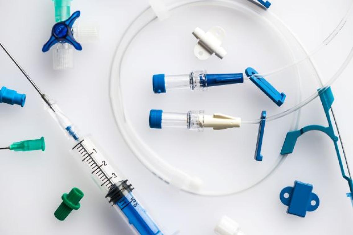 plastic tubing with blue clips, taps and end pieces and a syringe with needs attached