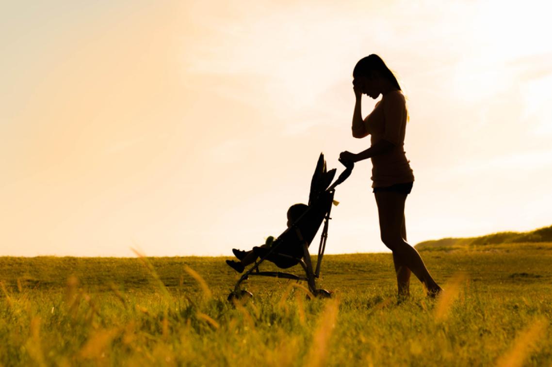 A silhouette of a mum with a baby in a pram.