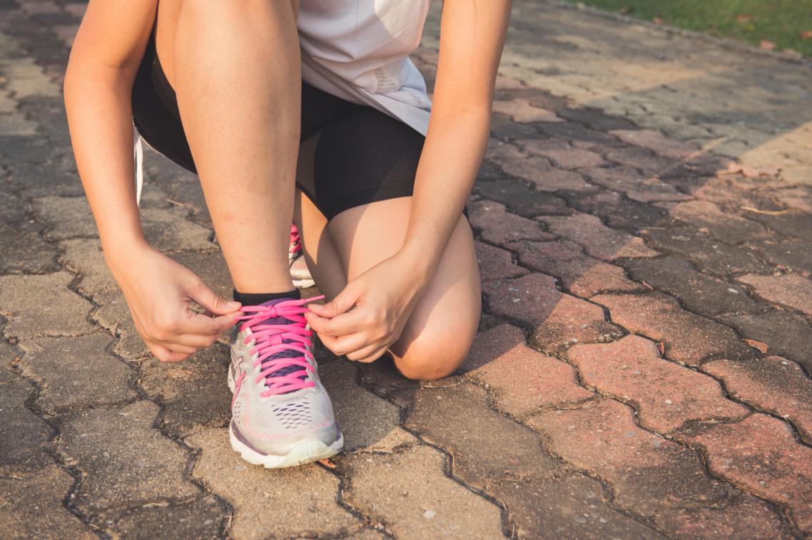 Woman tying shoelace.