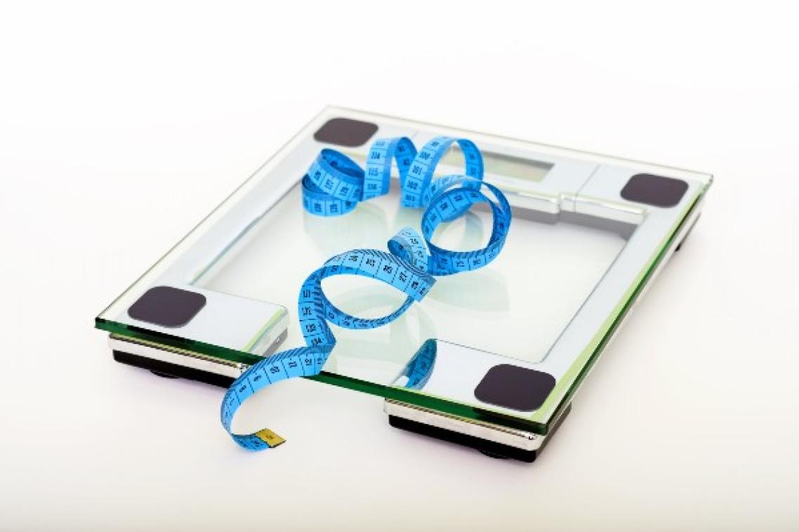 Scale with a blue tape measure on top.