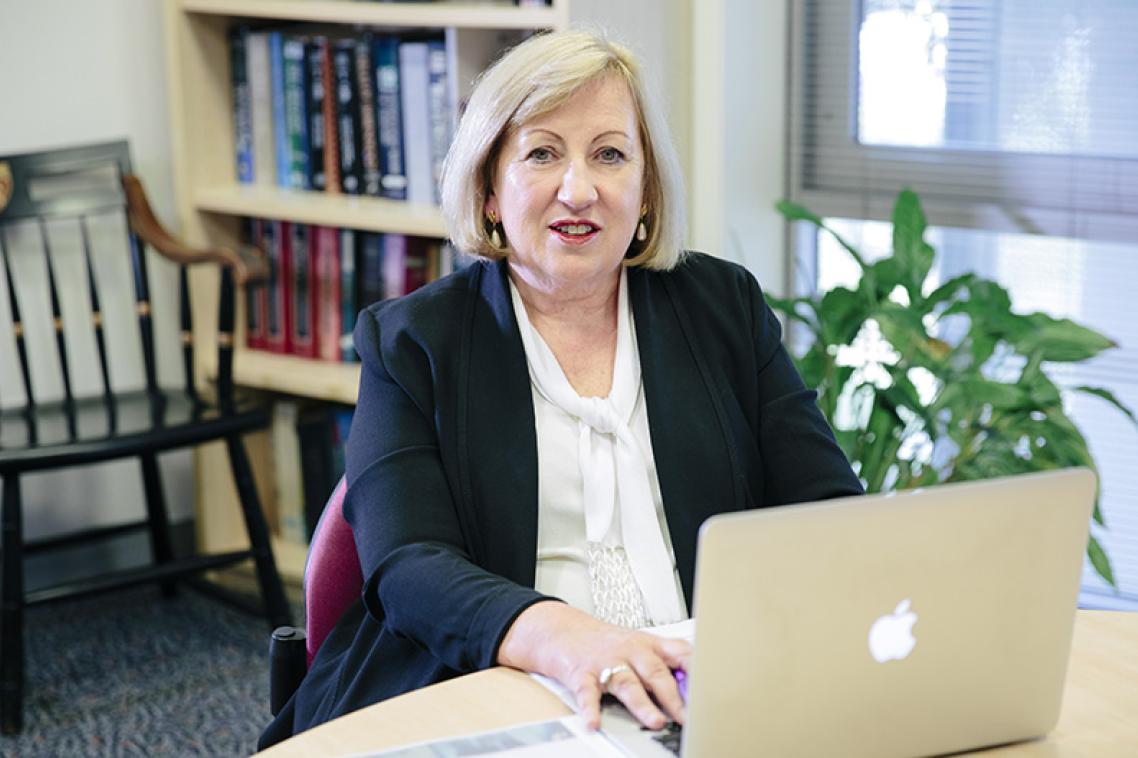 Professor Jennifer Stow sitting at a desk in front of a laptop