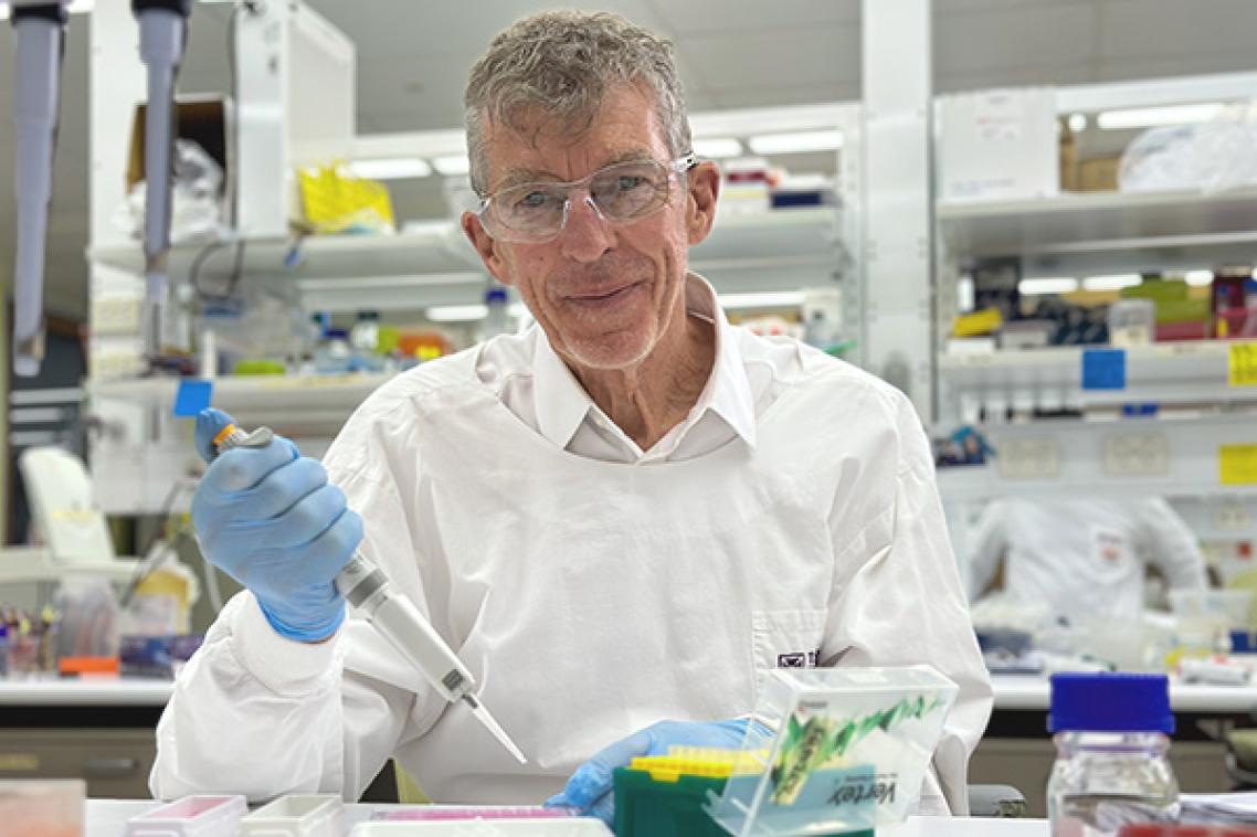 Emeritus Professor Ian Frazer uses a pipette in a lab at TRI