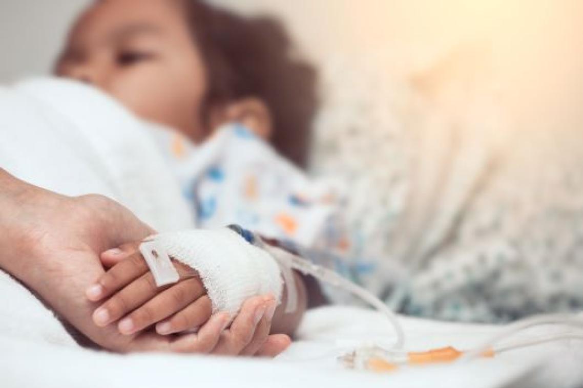 Sick child in a hospital bed with a drip