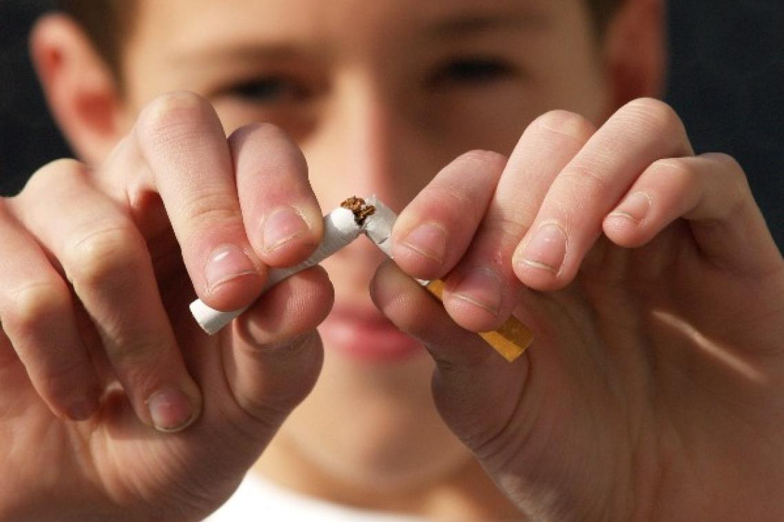 Close-up of man's fingers tearing apart a cigarette.