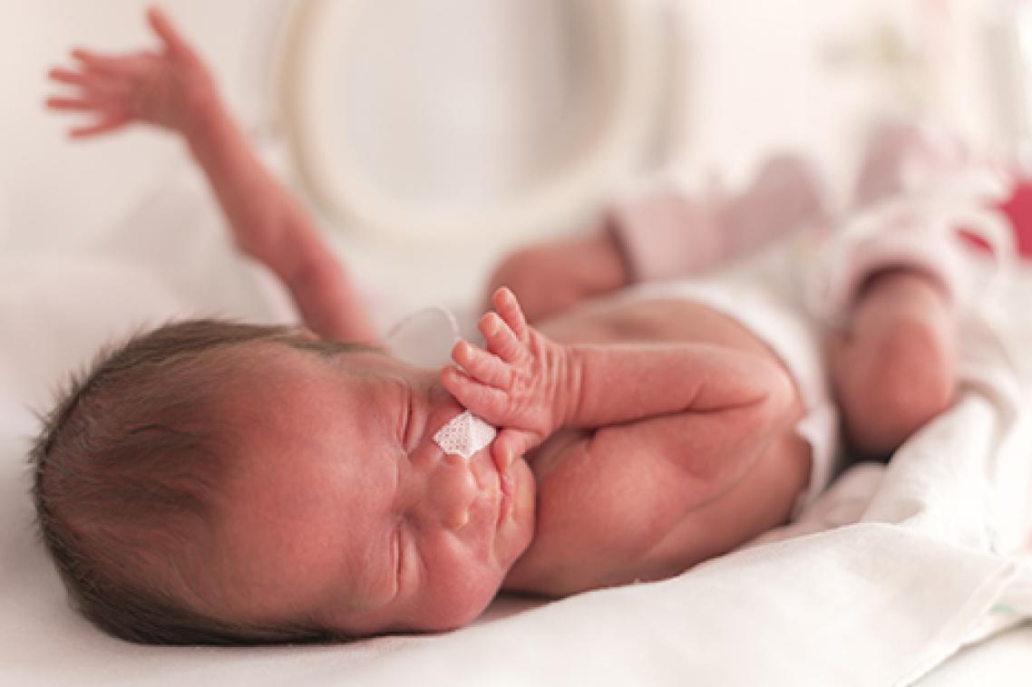 Newborn baby wearing a nappy with hands outstretched