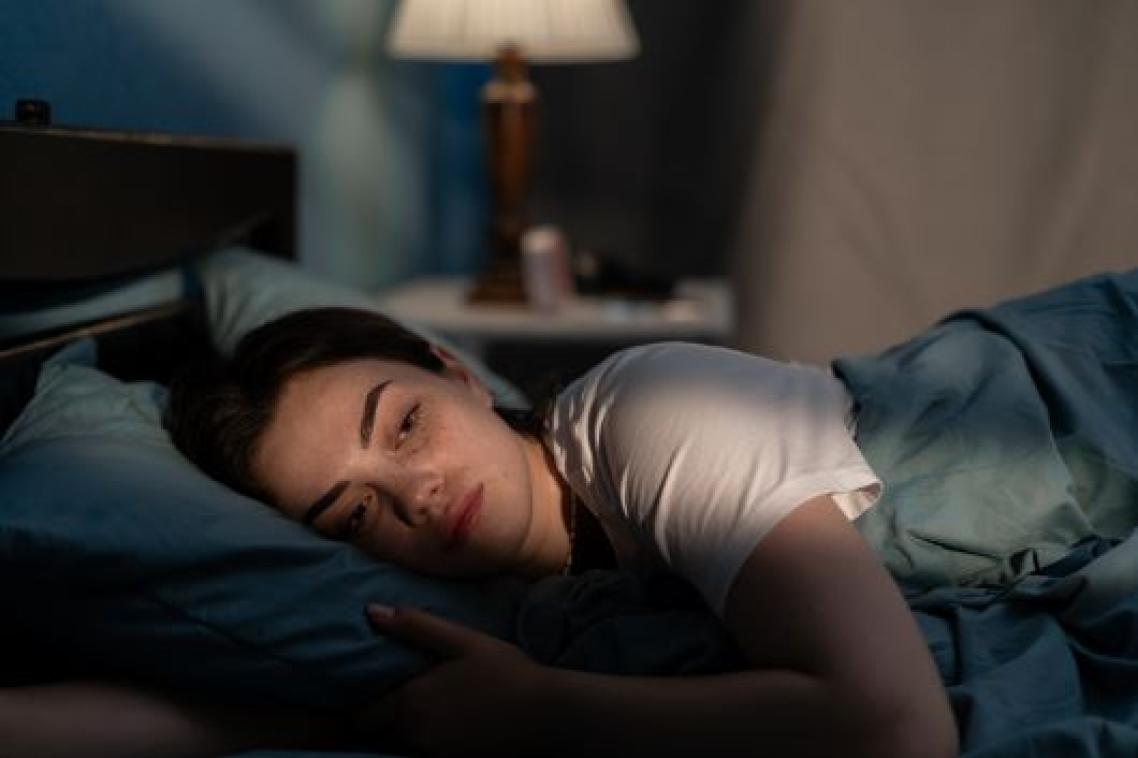 Sad woman lying on bed