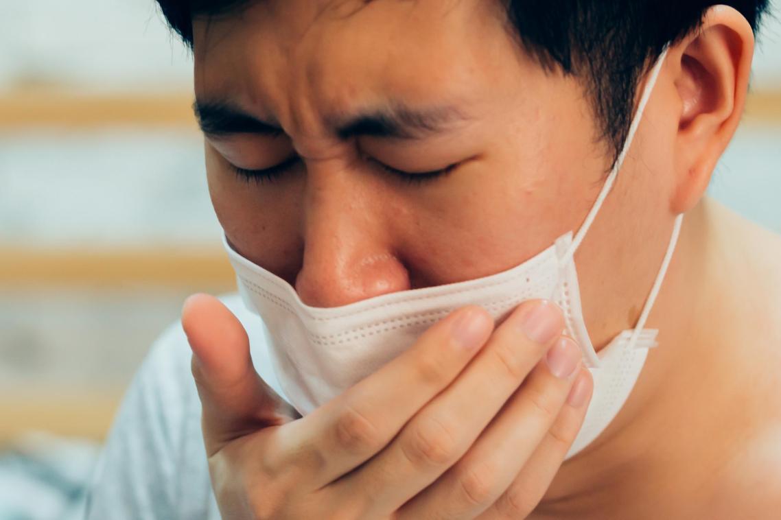 Man with mask coughing