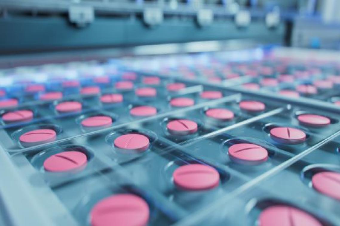 A close up image of trays of pink pills in production.
