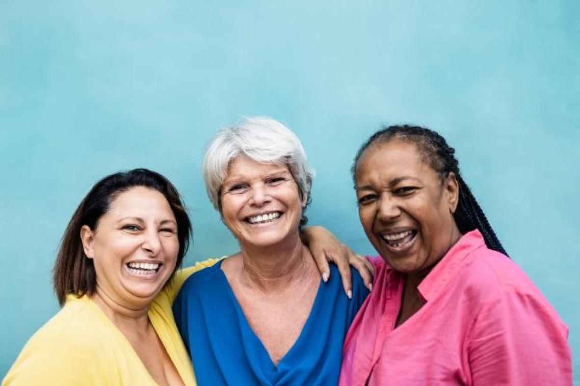 Three women of different ethnicities posing and smiling