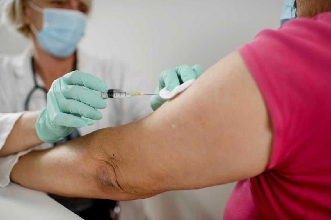 Vaccine being injected into older woman's arm.
