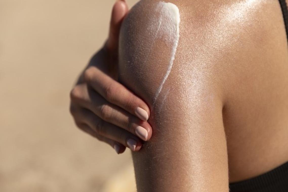 Women putting sunscreen on arm.