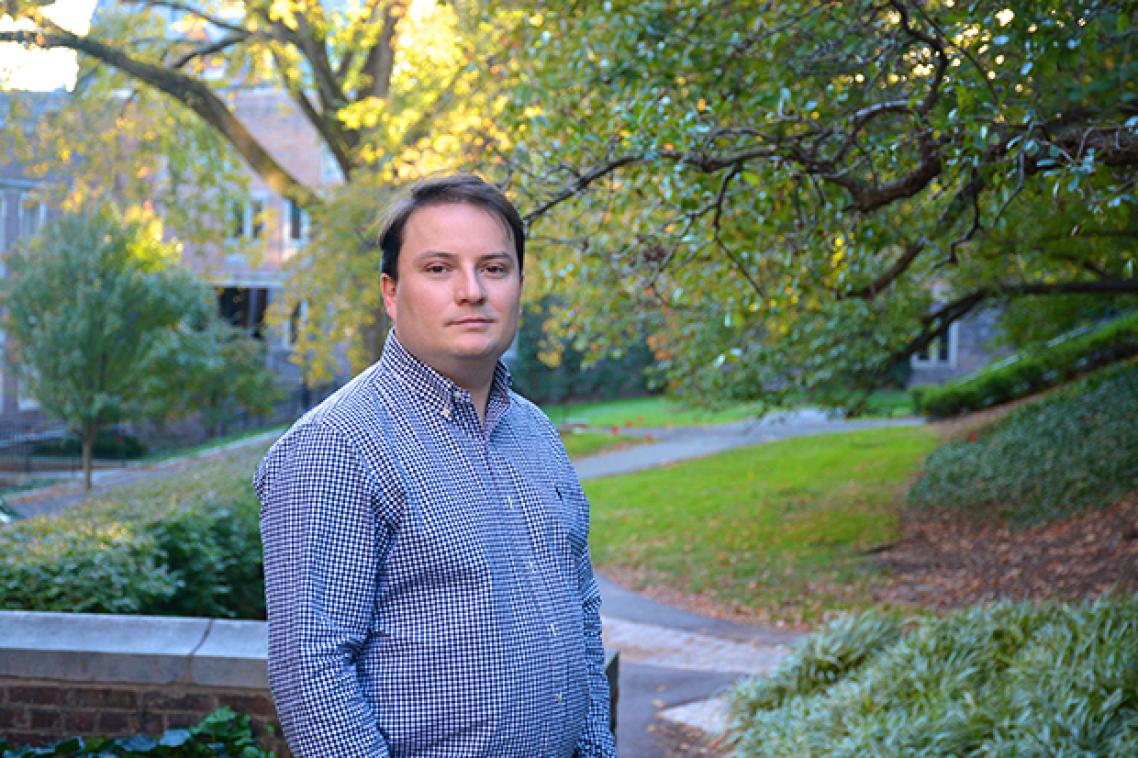 A man in a blue shirt in a garden