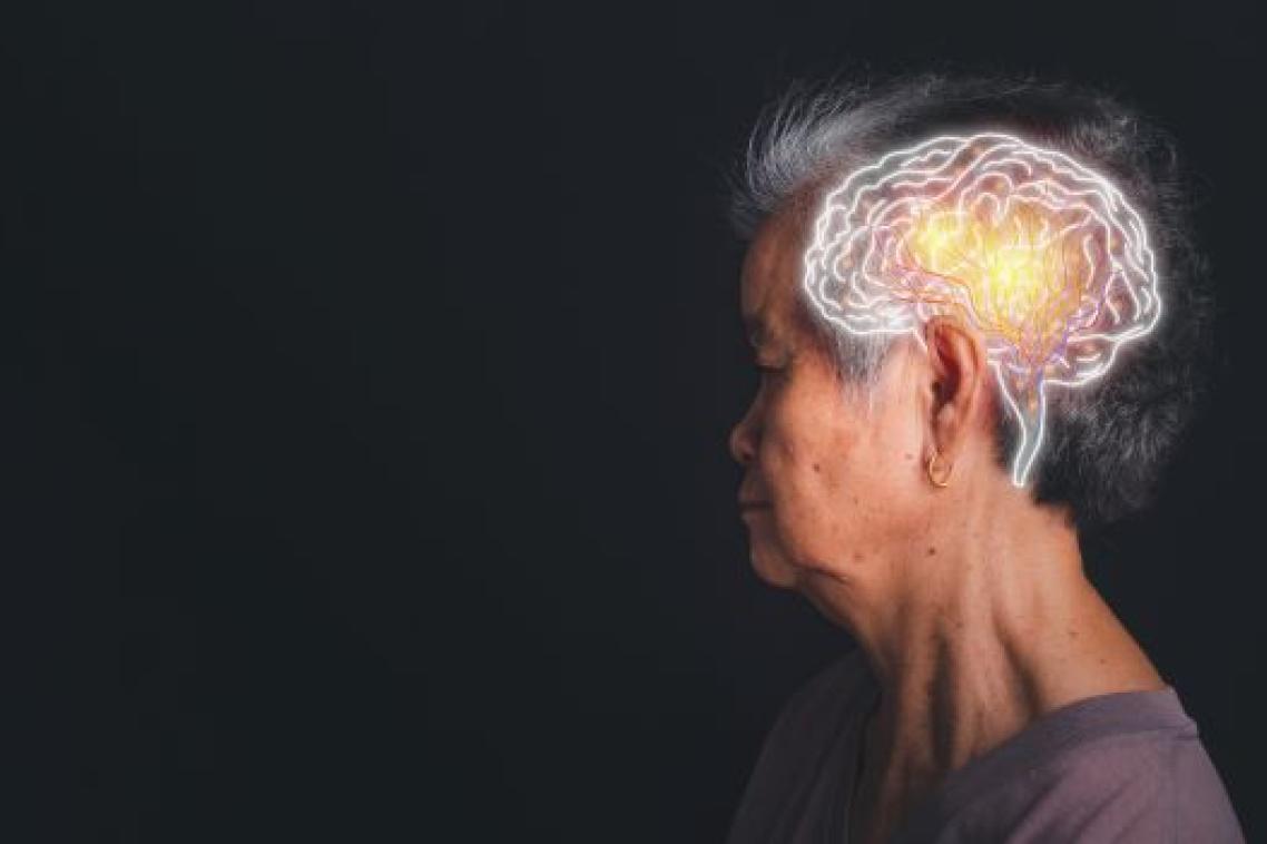 a woman with short grey hair looks to the left on a black background, a white superimposed drawing of a brain is on her head