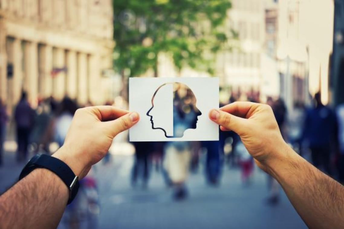 A man's hands holding a picture of the side profile of two faces. Adobe