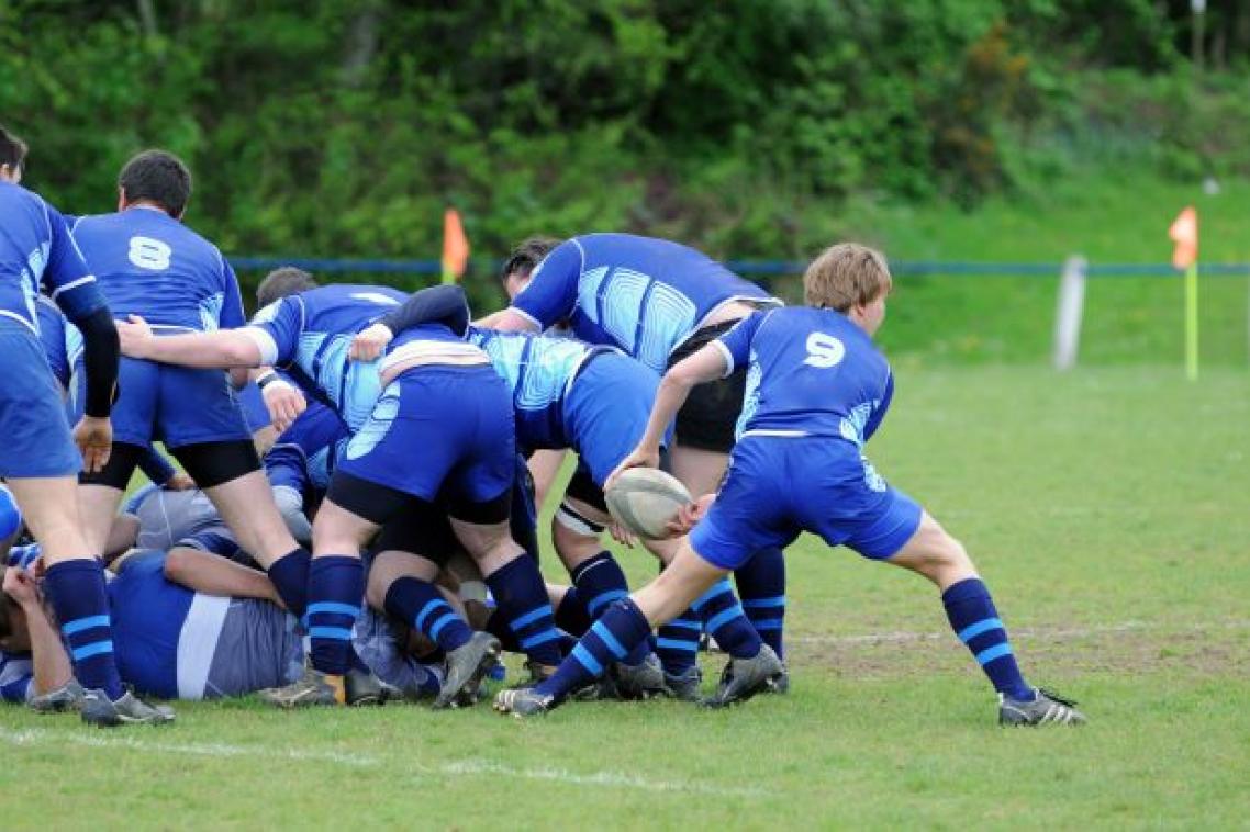 young rugby players in blue uniforms in a scrum
