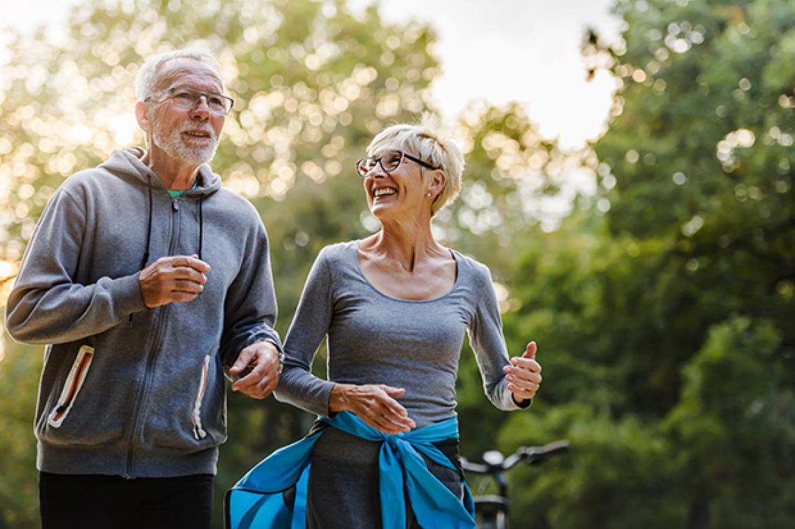 Older couple smiling and jogging. Adobe