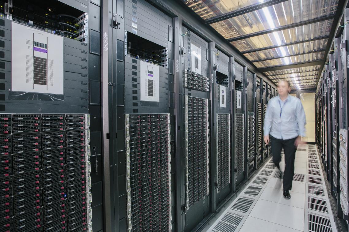 A man walks along a corridor in a data centre