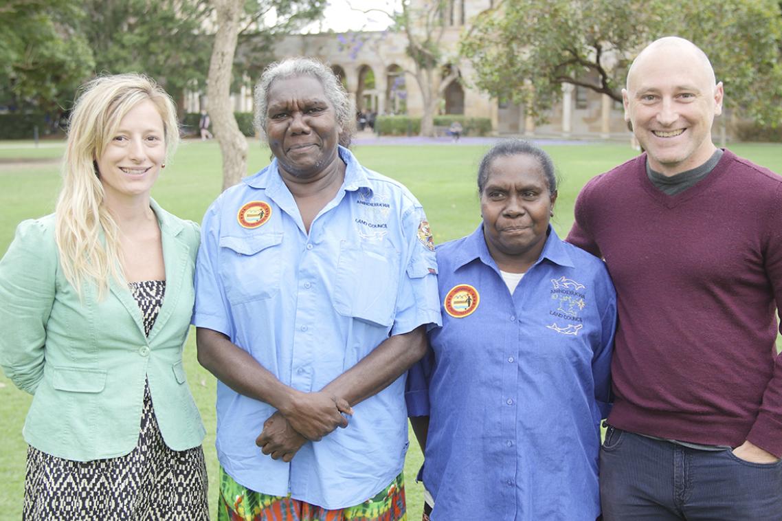 Three people standing on a grassy area 