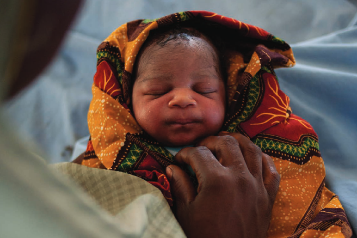Newborn baby wrapped in colourful cloth
