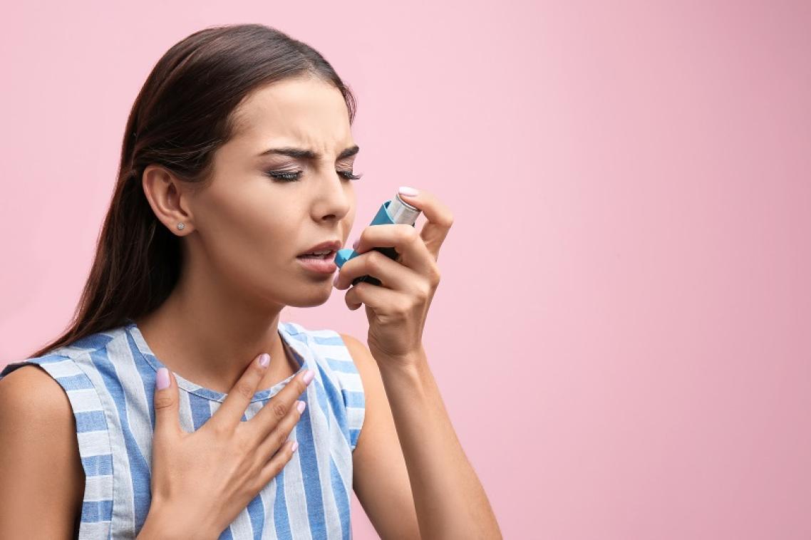 Woman holding asthma inhaler to her mouth