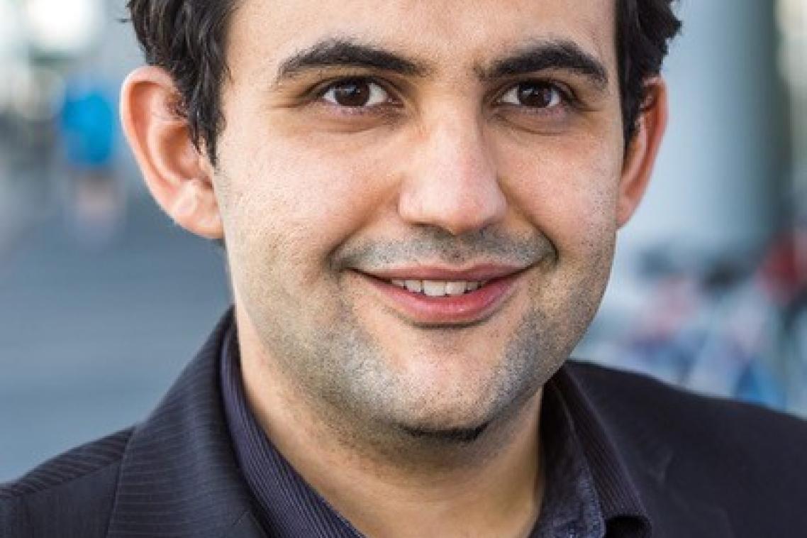 Head shot of a man in a black suit.