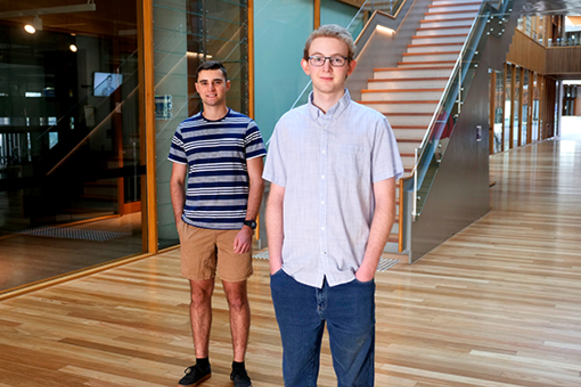 Two men standing in front of a staircase