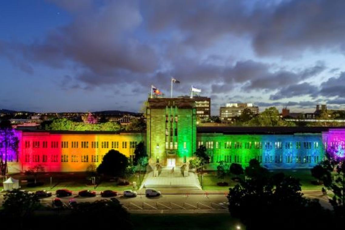 UQ's Forgan Smith Building lit up in rainbow colours.