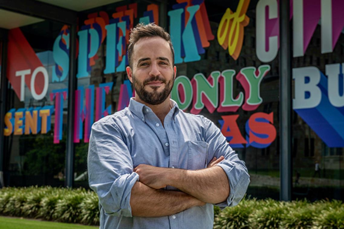 Brisbane artist Sam Cranstoun in front of his commissioned work wrapped around the UQ Art Museum at St Lucia