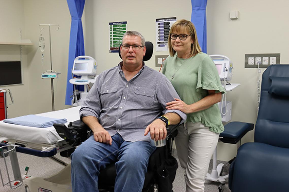 A man in a wheelchair with a woman standing beside him